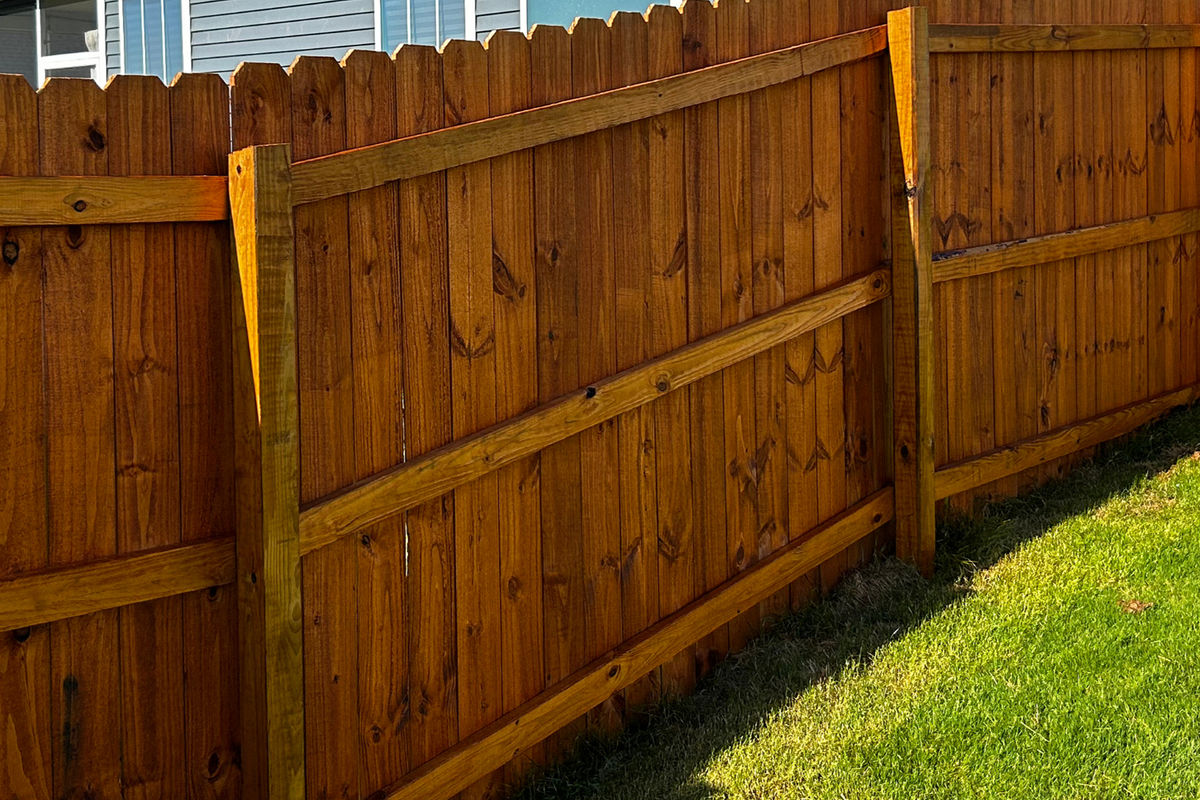 Honey-toned oil-stained privacy fence in Greenville SC