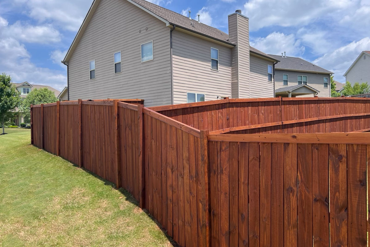 Wide oil-stained privacy fence in a Greenville backyard